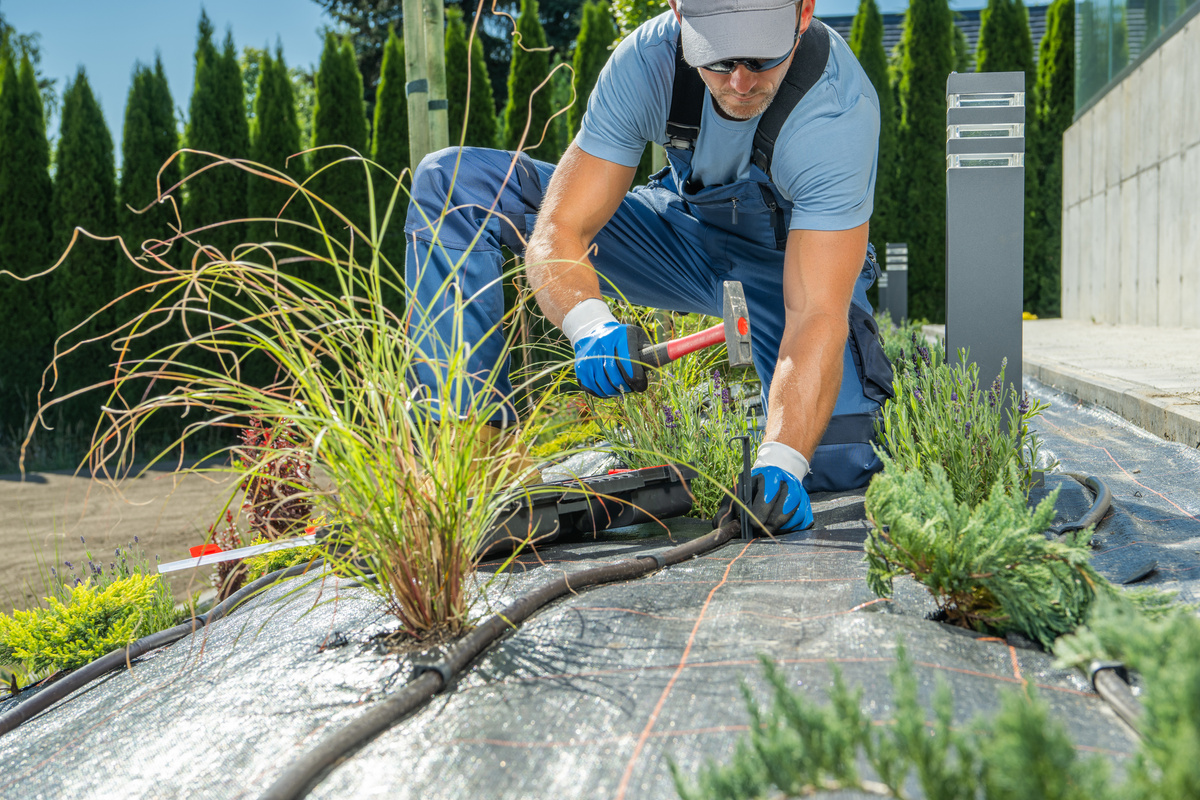 Gardener Installing Irrigation System Pipeline